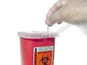 Photograph of red biohazard sharps disposal container.
