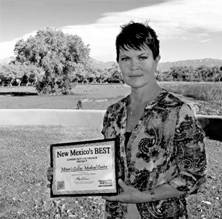 Black and white photo of Jeanine Peek standing outdoors holding a certificate.